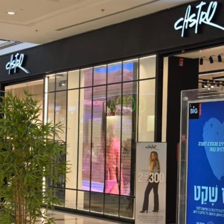 מסך גדול שבו מוקרן סרטון של אישה לבושה בגד ים: חלון הראווה של קסטרו שמסעיר חלק מהציבור החרדי בטבריה