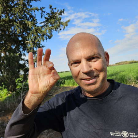 ניר דיסטלפלד, מפקח היחידה למניעת שוד ברשות העתיקות ובידיו החרפושית (צילום: אנסטסיה שפירו, רשות העתיקות)