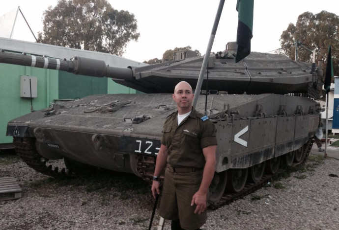 בריאן מאסט ליד טנק בבסיס צה"ל (צילום:  עמוד הפייסבוק של בריאן מאסט)