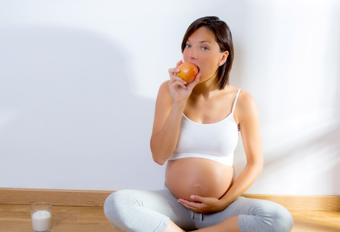 אישה בהיריון אוכלת (צילום:  אינג אימג')