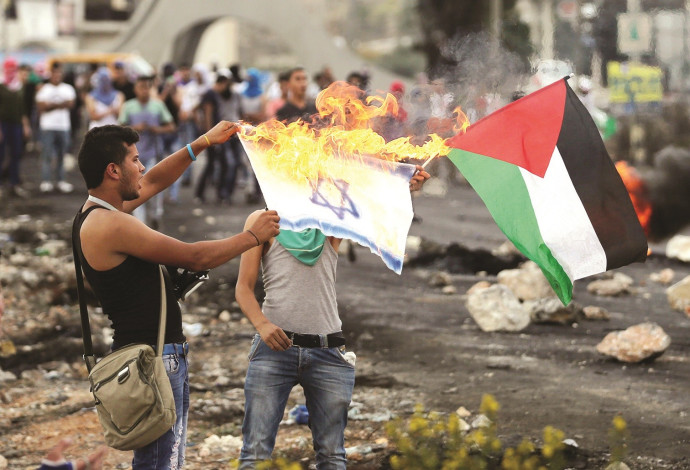 פלסטינים מציתים את דגל ישראל (צילום:  רויטרס)