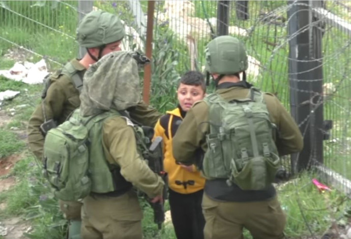 חיילים לוקחים ילד פלסטיני לחיפוש אחר מיידי אבנים, חברון (צילום:  מתוך סרטון "בצלם")