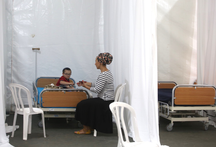 ילד חולה ואמו בבית חולים שדה שהוקם בגן סאקר (צילום:  מרק ישראל סלם)