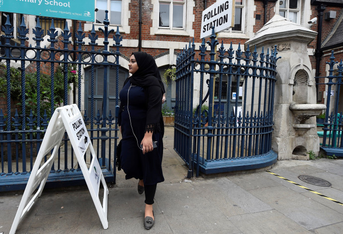צעירה מוסלמית מצביעה בבריטניה (צילום:  רויטרס)