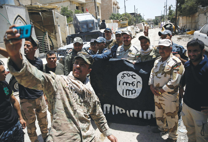 לוחמי הצבא העיראקי עם דגל דאעש (צילום:  רויטרס)