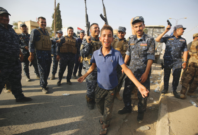 תושבים וחיילים בעיראק חוגגים את שחרור מוסול (צילום:  AFP)
