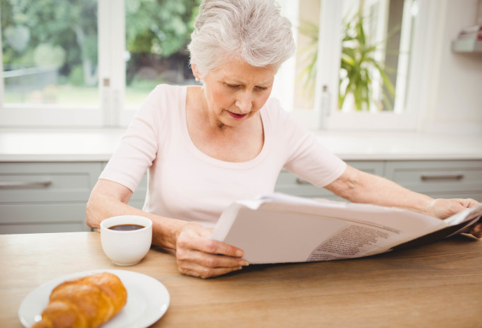אישה מבוגרת קוראת עיתון, צילום אילוסטרציה (צילום:  istockphoto)