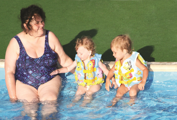 אישה עם ילדים בבריכה (צילום:  אינג אימג')