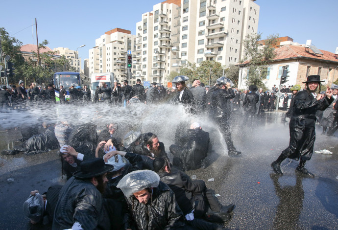 זרנוקי מים מופעלים על מפגינים חרדים נגד גיוס לצה"ל (צילום:  מרק ישראל סלם)