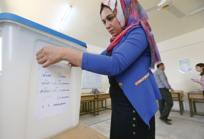 עובדת מכינה את עמדת ההצבעה למשאל העם הכורדי בעיראק (צילום:  אלי דסה)