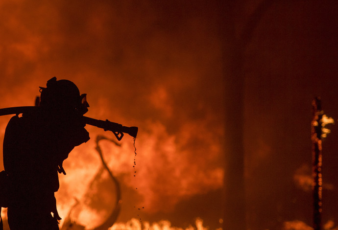לוחם אש נלחם בשריפה (צילום:  AFP)