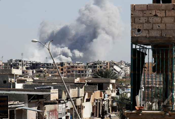 עשן עולה לאחר הפצצה בעיר הסורית א-ראקה (צילום:  רויטרס)