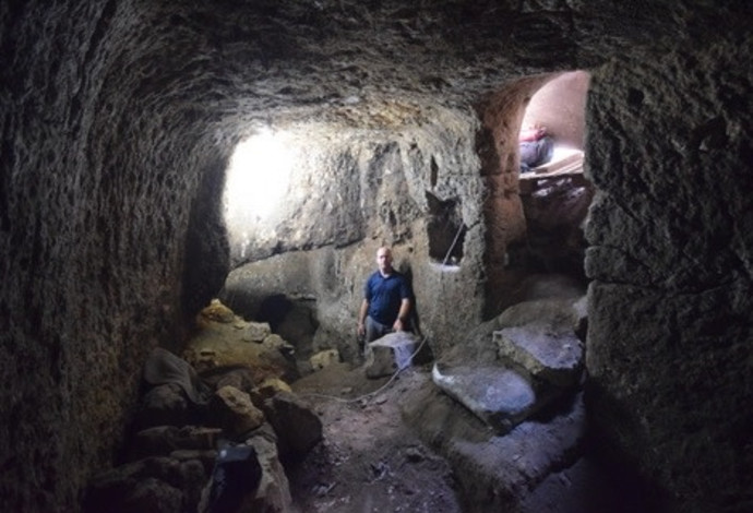 מפקח רשות העתיקות בתוך מערכת המערות החצובה בכפר עילבון (צילום:  רשות העתיקות)