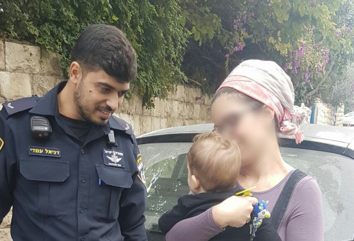 האם, בנה והשוטר שחילץ את התינוק (צילום:  דוברות המשטרה)
