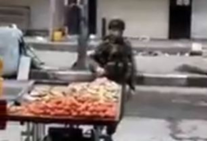 חייל תועד כשהוא לוקח תפוחי אדמה מדוכן של פלסטיני בחברון (צילום:  צילום מסך)