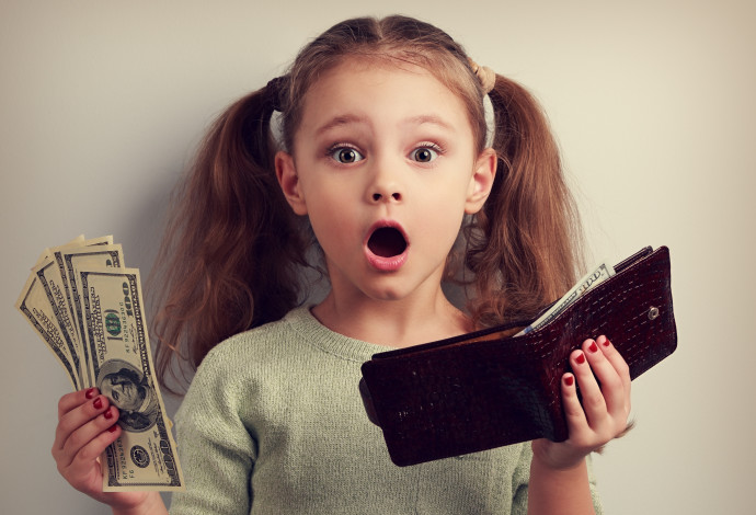ילדה קטנה מחזיקה כסף, צילום אילוסטרציה (צילום:  istockphoto)