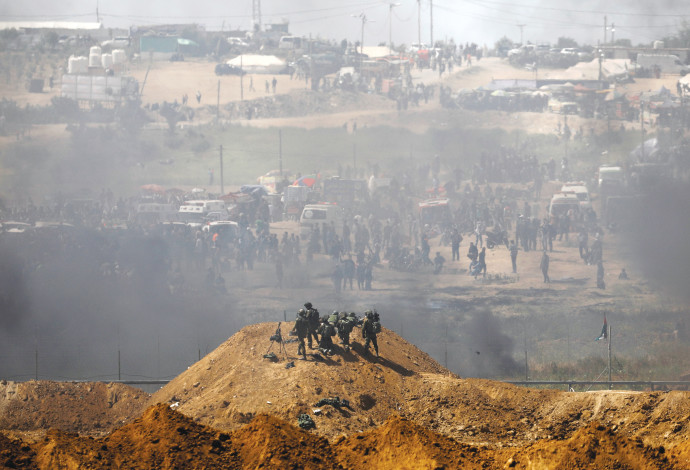 חיילים ישראלים ופלסטינים על הגדר בגבול עזה-ישראל  (צילום:  רויטרס)