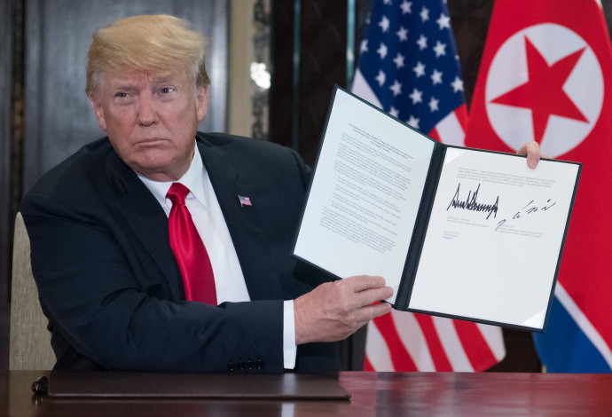 דונלד טראמפ עם ההסכם שנחתם עם קוריאה הצפונית (צילום:  AFP)