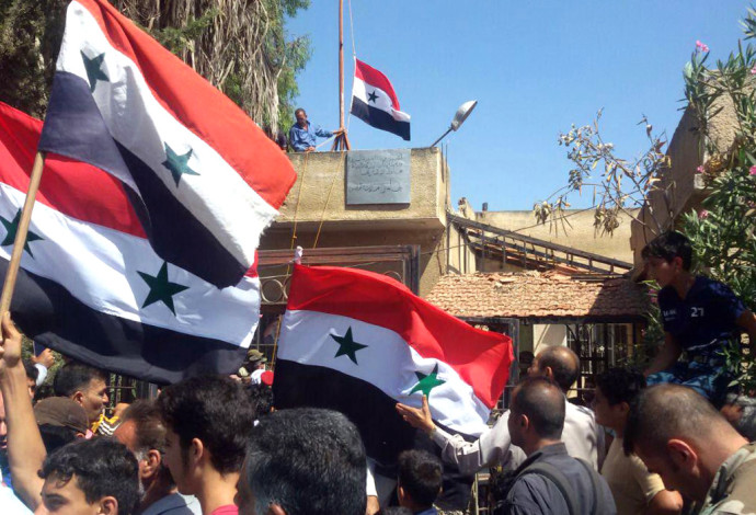 הנפת דגלי סוריה בדרעא (צילום:  AFP)