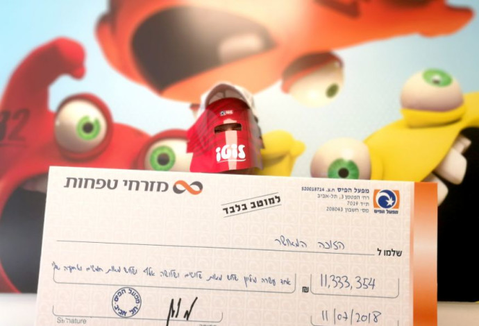 הזוכה המאושר מצטלם עם הצ'ק  (צילום:  דניאל שטרנהיים)