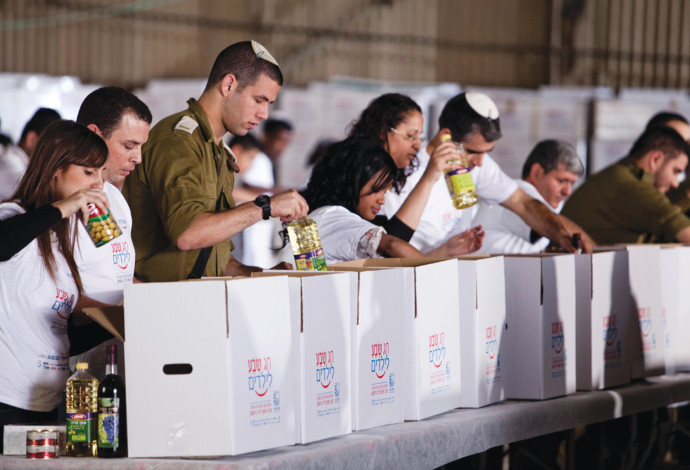 מתנדבים אורזים חבילות מזון (צילום:  עמותת מגדל אור)