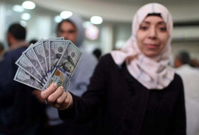 עובדת חמאס מציגה דולרים לאחר שקיבלה את משכורתה (צילום:  רויטרס)