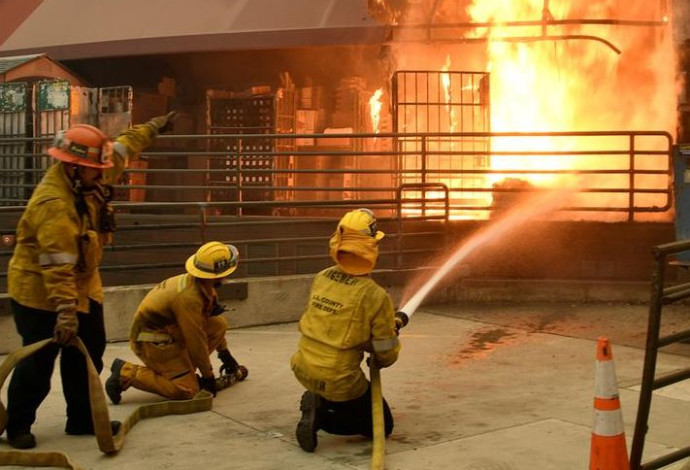 הכבאים מנסים להשתלט על סניף דואר שעלה באש במליבו (צילום:  רויטרס)