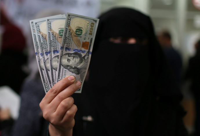 עובדת חמאס בעזה מציגה דולרים לאחר שקיבלה משכורת מקטאר (צילום:  רויטרס)