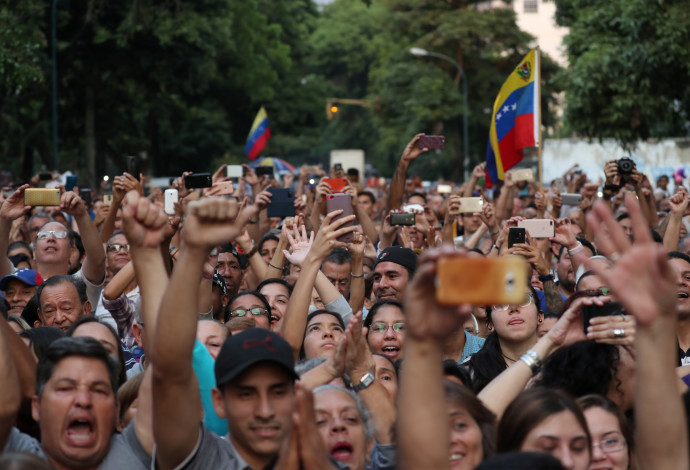 מפגינים בוונצואלה מריעים למנהיג האופוזיציה, חואן גואידו (צילום:  רויטרס)