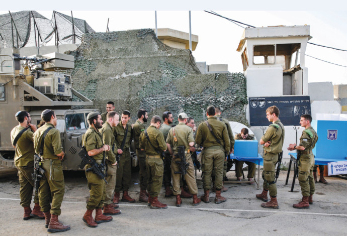 חיילים מצביעים בבסיס ליד גבול עזה (צילום:  AFP)