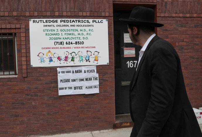 שלט המזהיר מפני חצבת בקהילה היהודית בברוקלין (צילום:  רויטרס)