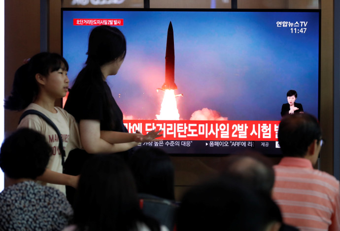 אזרחים צופים בניסוי הצבאי בקוריאה הצפונית (צילום:  רויטרס)