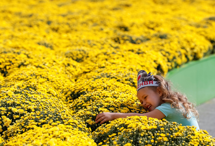 ילדה עומדת ליד מרבד פרחים (צילום:  רויטרס)