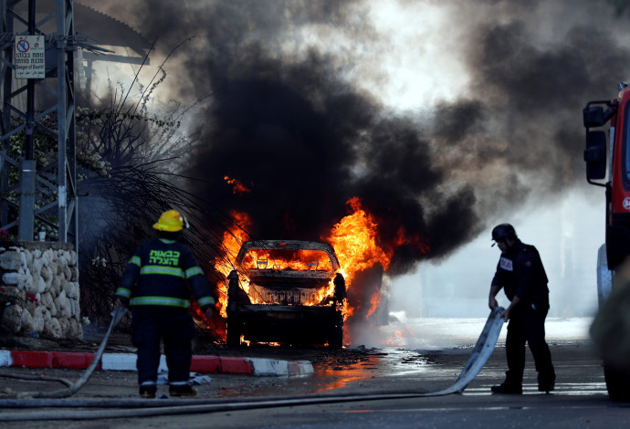 רכב עולה באש בשדרות לאחר פגיעת רקטה (צילום:  רויטרס)