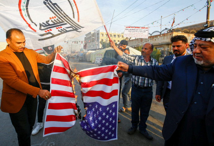 מפגינים עיראקים שורפים את דגל ארה"ב (צילום:  רויטרס)