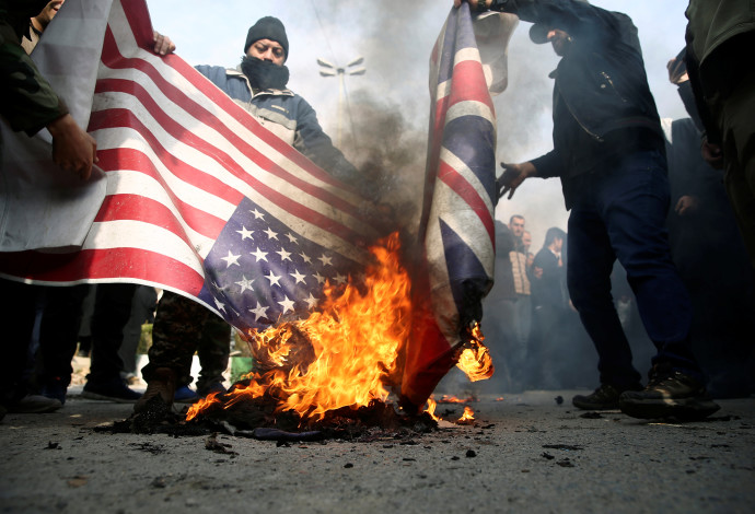 מפגינים באיראן שורפים דגל ארצות הברית  (צילום:  רויטרס)