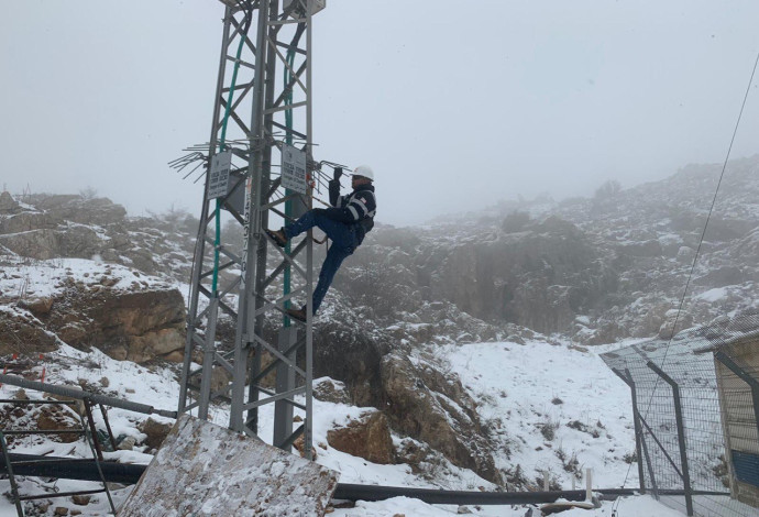 איש חברת החשמל בשלג (צילום:  רשתות חברתיות)