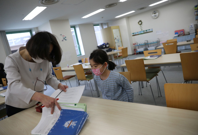 נגיף הקורונה: ילדה ומורה עם מסכות ביפן (צילום:  רויטרס,STOYAN NENOV)
