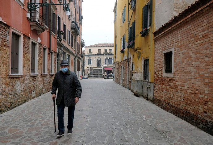 הקורונה: מבוגר עוטה מסכה ברחוב שומם בונציה (צילום:  REUTERS/Manuel Silvestri)