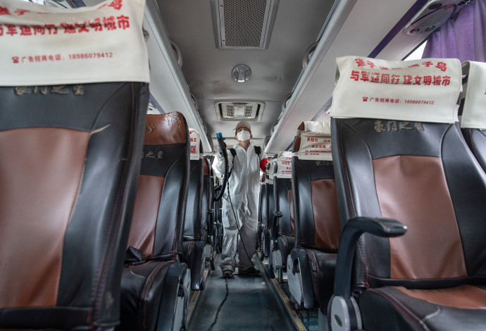 קורונה - חיטוי אוטובוס נוסעים בווהאן, סין (צילום:  STR/AFP via Getty Images)