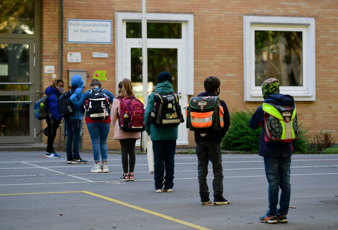 קורונה - תלמידים ממתינים בכניסה לבית ספר בגרמניה (צילום:  INA FASSBENDER/AFP via Getty Images)