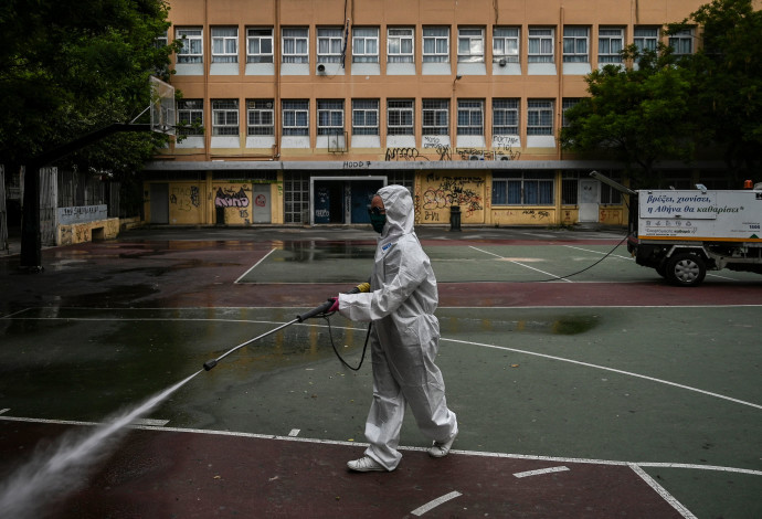 קורונה - חיטוי בית ספר באתונה (צילום:  ARIS MESSINIS/AFP via Getty Images)