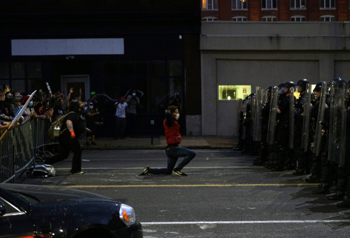 מפגין בארה"ב כורע ברך מול שוטרים (צילום:  רויטרס)