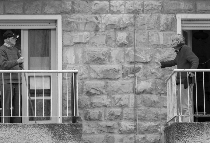 קשישים משוחחים מהמרפסת, מתוך פרויקט "חיבור מצולם" (צילום:  דור פזואלו)