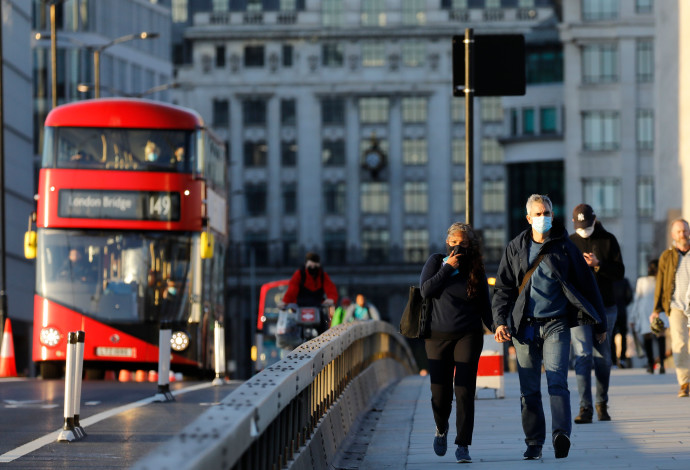 קורונה - אנשים עם מסכה ברחובות לונדון (צילום:  TOLGA AKMEN/AFP via Getty Images)