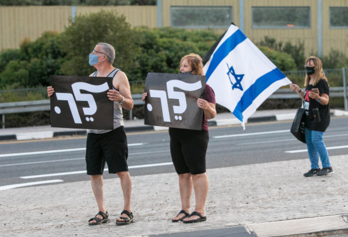 מפגינים נגד נתניהו מחזיקים שלט "לך" (צילום:  ענת חרמוני, פלאש 90)