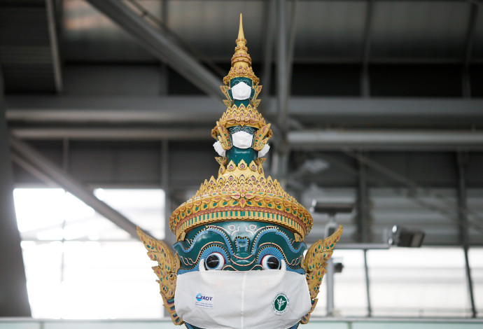 פסל מסורתי תאילנדי שהוסיפו לו מסכה נגד קורונה (צילום:  REUTERS/Soe Zeya Tun)