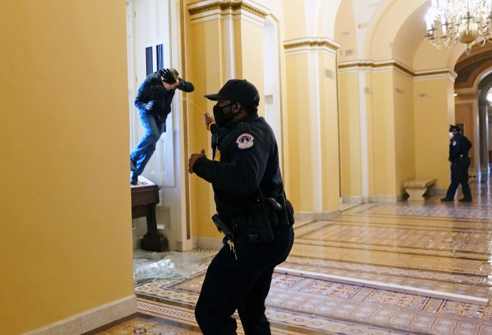 שוטרים אמריקאים מרססים בספרי פלפל את המפגינים שפרצו לבניין הקפיטול (צילום:  Kevin Dietsch/Pool via REUTERS)