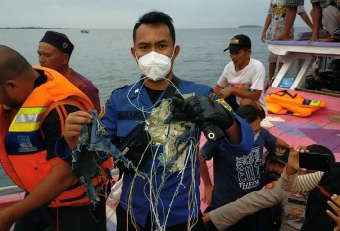 דייגים עם שרידי המטוס שהתרסק באינדונזיה (צילום:  INSTAGRAM @HUMASJAKFIRE/via REUTERS)