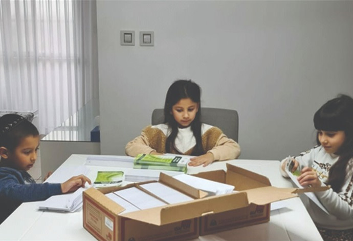 מעיין אדל ודניאל מכינים מעטפות לכרטיסי אדי (צילום:  רוזה אברמוב, המרכז הלאומי להשתלות)